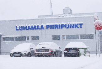 Piiripunkti hoone talvel, maja ees seisavad kolm autot. 